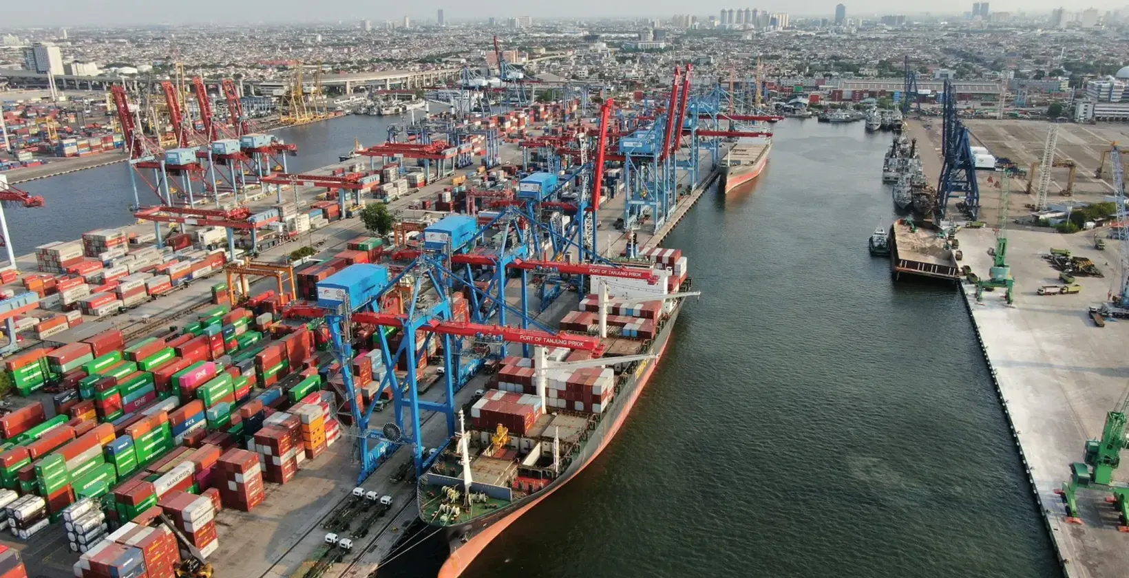 Aerial view of a container port with ships, cranes and stacked containers